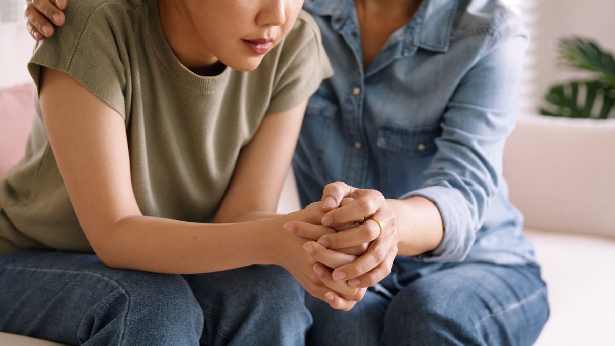 Two people sitting together and holding hands